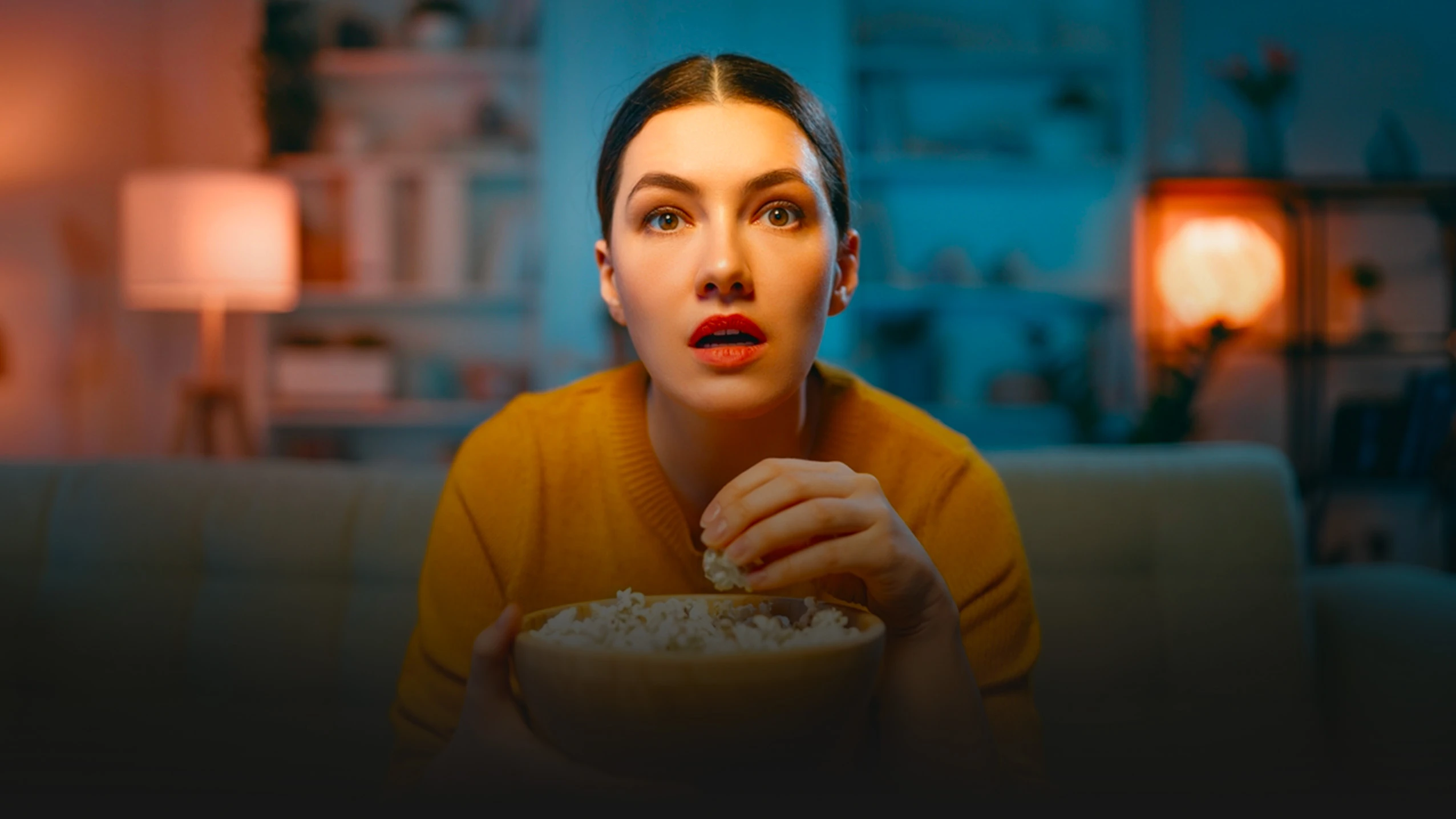 Vrouw geniet van IPTV met popcorn